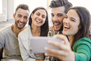 Group of friends smiling and taking a selfie after receiving cosmetic dentistry, Downey CA