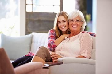 Mother and daughter sitting and smiling after dental implants, Downey CA