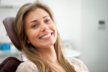 Young woman in patient chair smiling after dental bonding treatment, Downey CA
