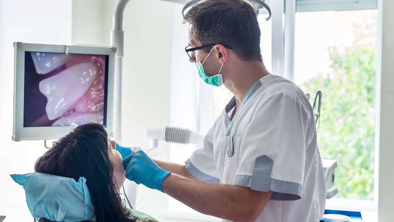 Dentist looking at patients mouth with camera, downey ca