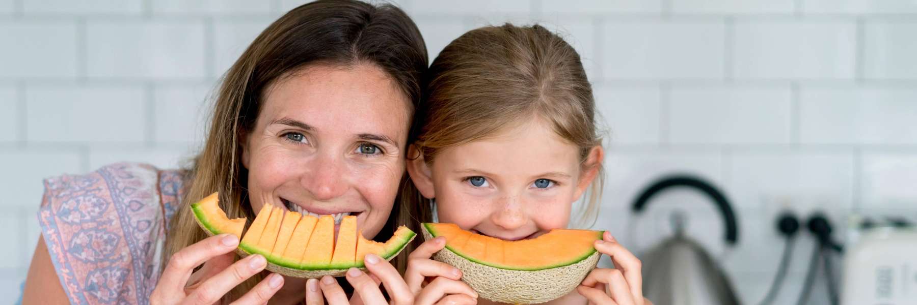 Mom and daughter smiling before eating cantaloupe, downey ca